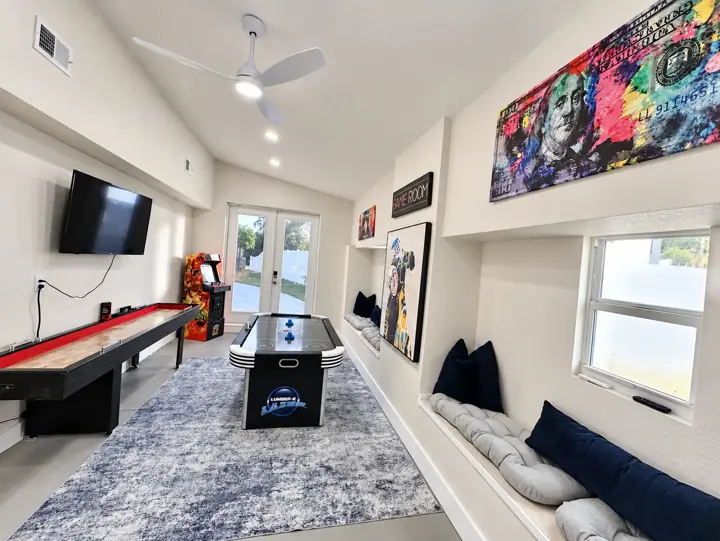 Game room with air hockey, shuffleboard, an arcade cabinet and a TV