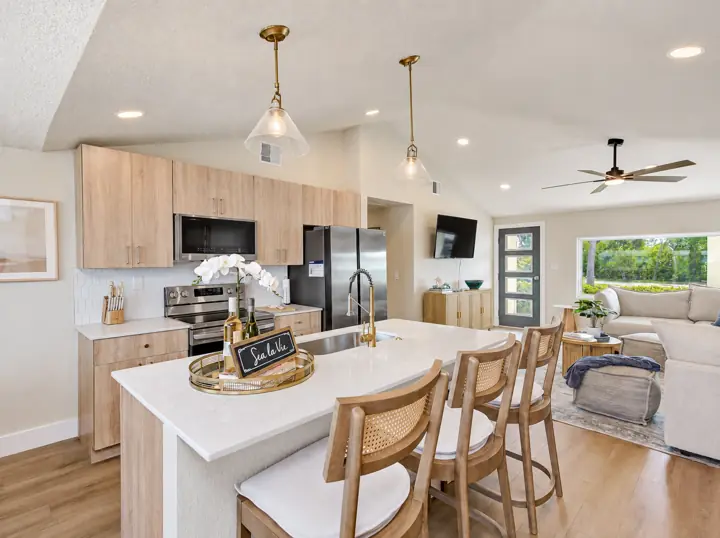 Kitchen island with three stools, open to the living room